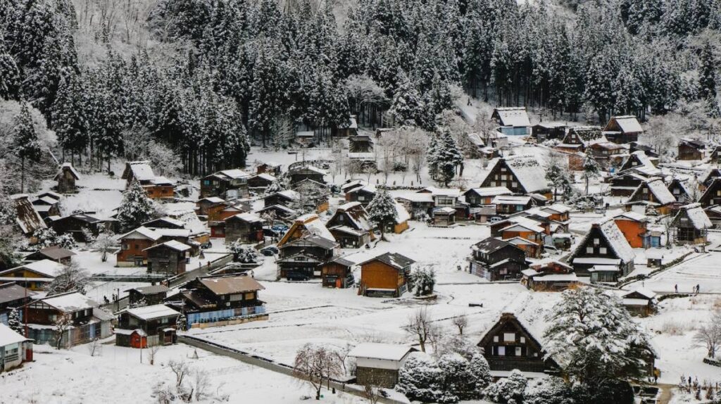 A picturesque snowy village nestled among tall trees, featuring traditional wooden houses and a serene, wintry landscape.